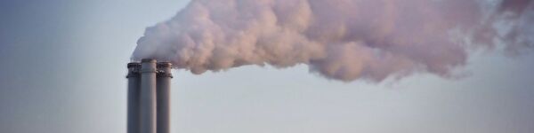 Image of a chimney stack belching smoke against a grey sky