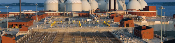 Wastewater treatment works with aeration lanes in foreground and digesters in background