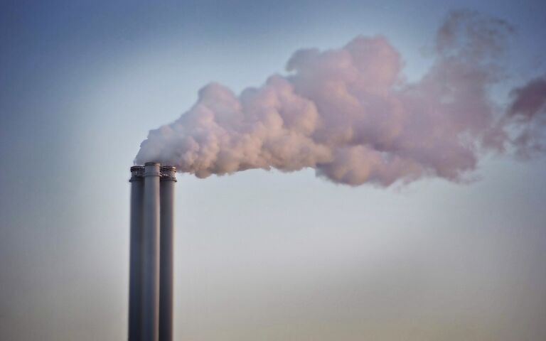 Image of a chimney stack belching smoke against a grey sky.